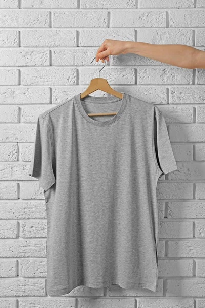 gray t-shirt against brickwall