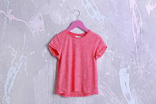 Pink t-shirt against grunge wall — Stock Photo, Image