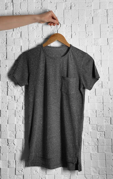 T-shirt gris contre le mur de briques — Photo