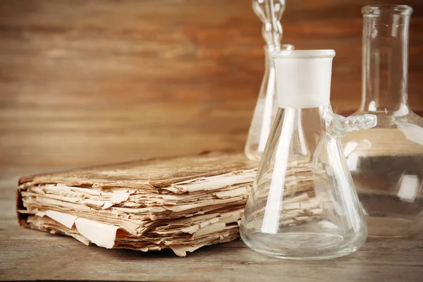 Flacons en verre et vieux livre — Photo