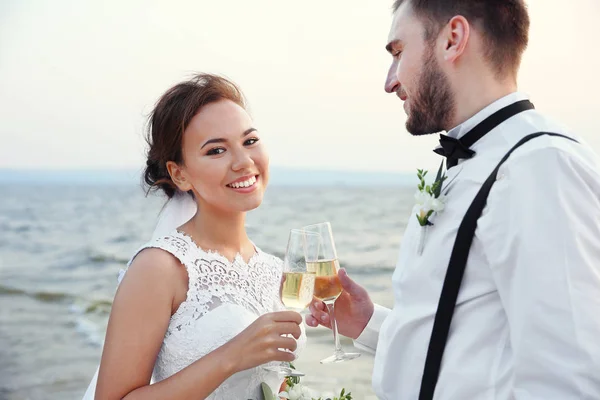 Sposo e sposa con bicchieri di champagne — Foto Stock