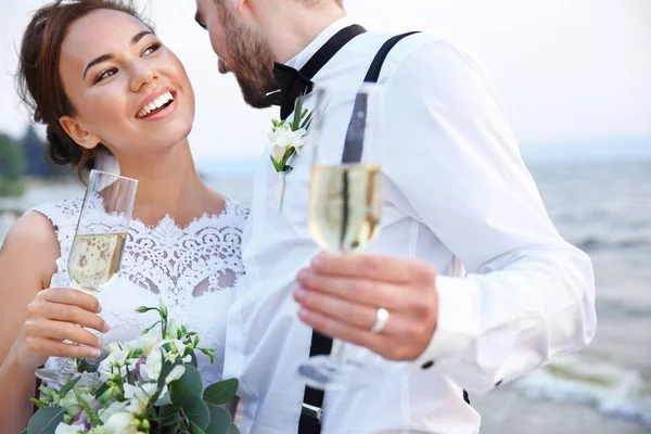 Sposo e sposa con bicchieri di champagne — Foto Stock