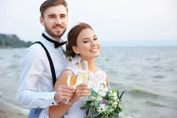 Brudgum och brud med glas champagne — Stockfoto