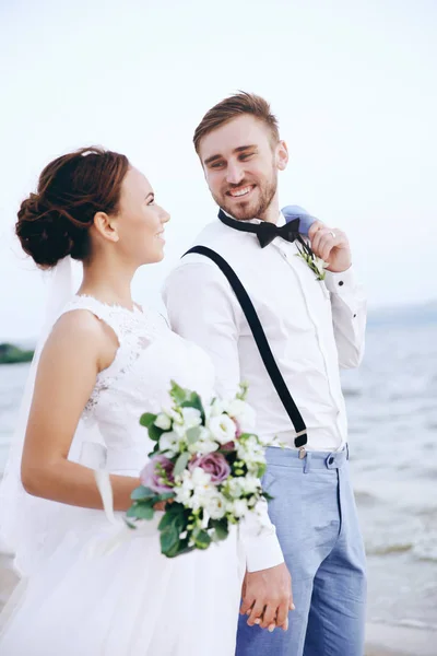 Novio y novia en la orilla del río — Foto de Stock