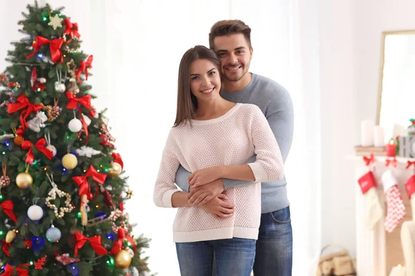 Paar in de buurt van de kerstboom — Stockfoto