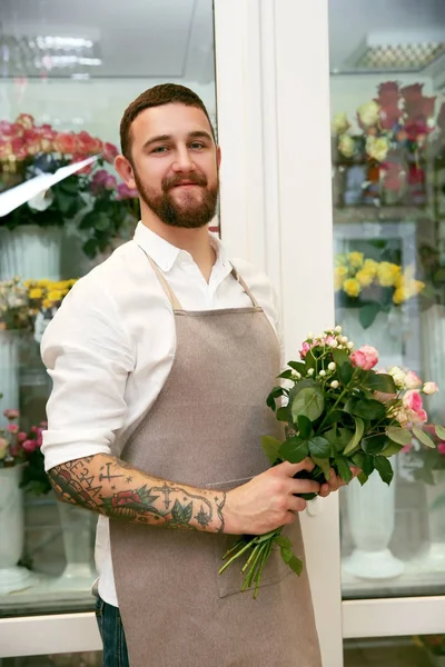 Handsome florist with bouquet — Stock Photo, Image