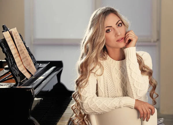 Mooie vrouw op piano — Stockfoto