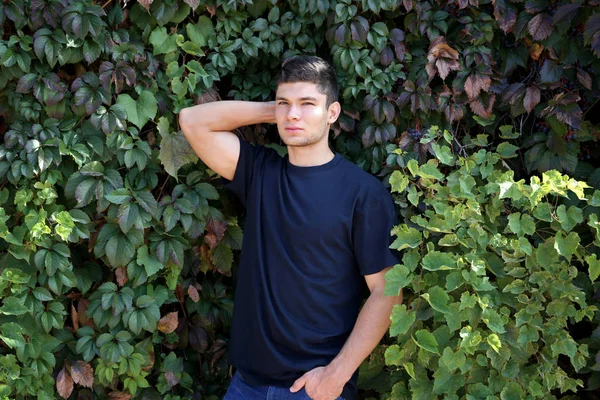 Homem bonito em folhas verdes — Fotografia de Stock