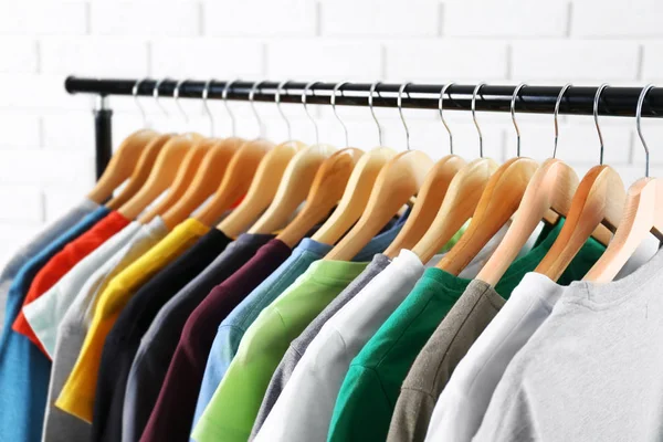 Colorful t-shirts on hangers — Stock Photo, Image