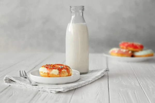 Plate with donut and bottle of milk