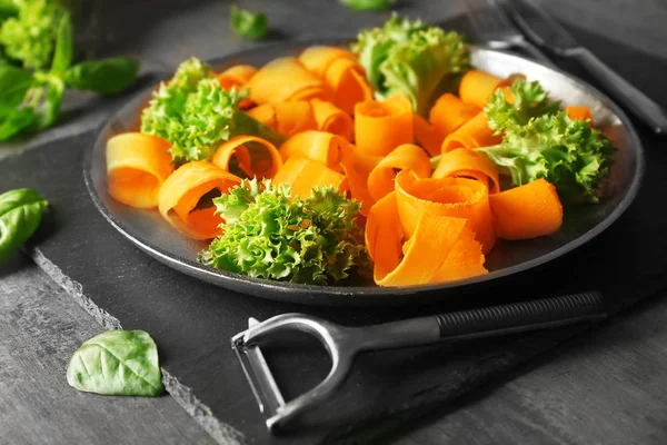 Тарелка с нарезанной морковью и салатом — стоковое фото