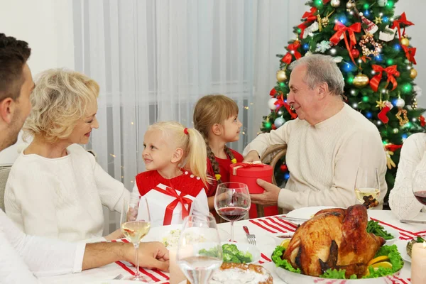 Mutlu aile Noel yemeğini oturma odasında yiyor.
