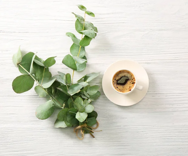 Eucalyptus branches with cup of coffee — Stock Photo, Image