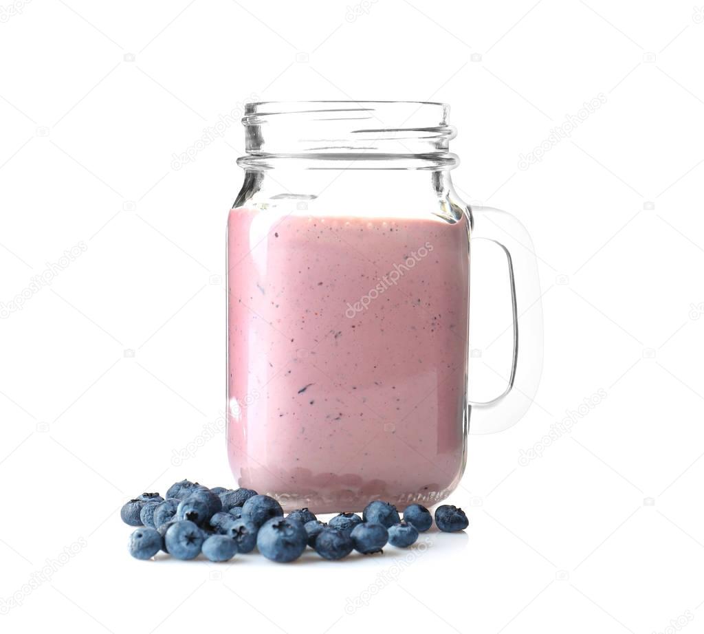 Mason jar with tasty smoothie and blueberries
