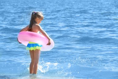 Neşeli küçük kız pembe hayat ile halka suda