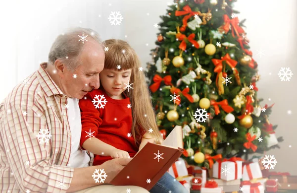 祖父の部屋で小さな孫娘に本を読んでは クリスマスの装飾 クリスマスのお祝いのコンセプトです 雪の効果 — ストック写真