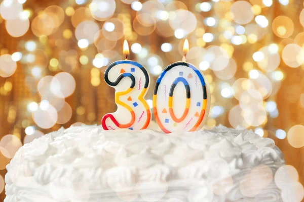 Lighted candles on birthday cake — Stock Photo, Image