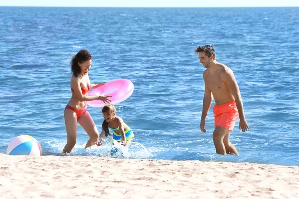 Conceito familiar. Jovem mulher, homem e menina brincando na costa do mar — Fotografia de Stock