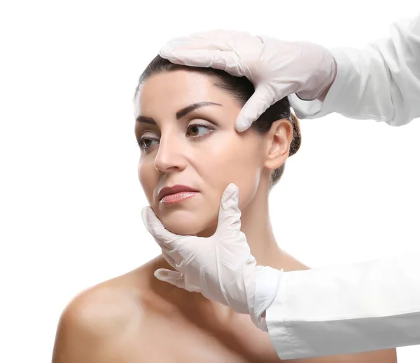 Surgeon hands examine female face — Stock Photo, Image