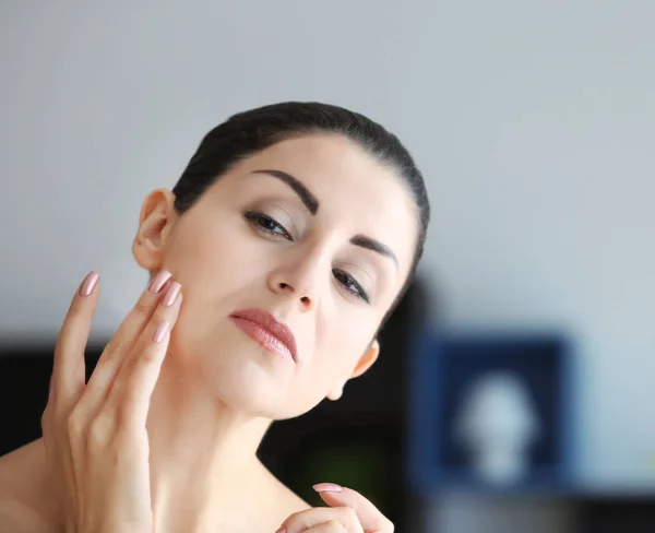 Mujer adulta revisando su cara — Foto de Stock