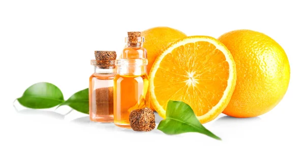 Oranges, leaves and bottles with essential oil on white background — Stock Photo, Image