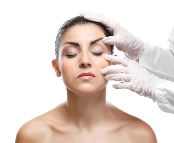 Surgeon hands examine female face Stock Photo