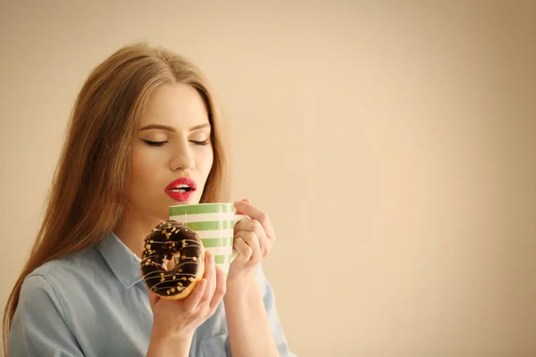 Женщина с вкусным пончиком — стоковое фото