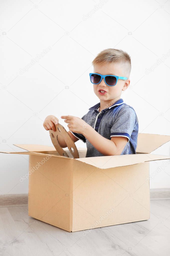 boy playing with cardboard box 