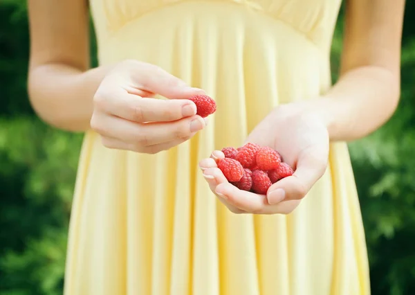 Woman holding raspberries — Stock Photo, Image