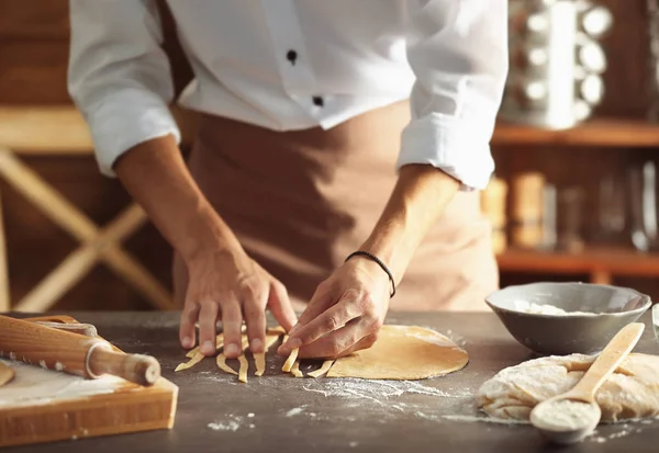 Muži Příprava těstovin na kuchyňském stole — Stock fotografie