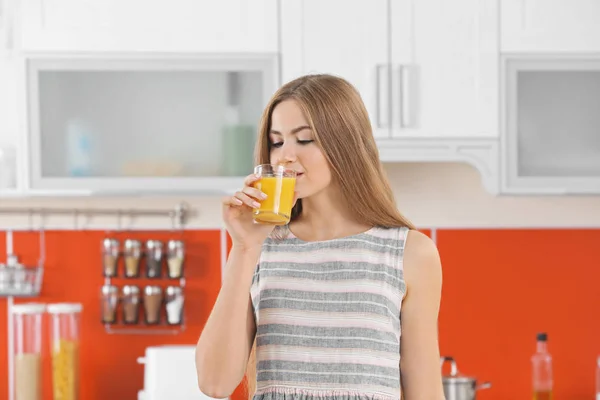 Mujer en cocina beber jugo — Foto de Stock