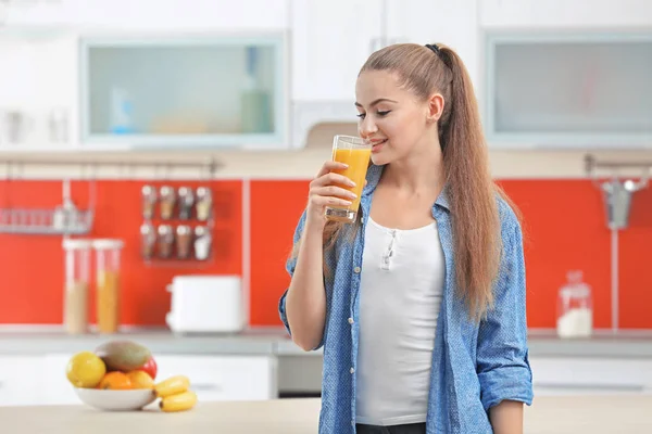 Kobieta w kuchni do picia sok — Zdjęcie stockowe