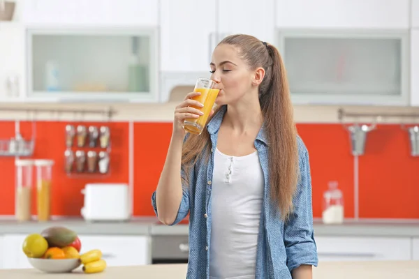 Kobieta w kuchni do picia sok — Zdjęcie stockowe