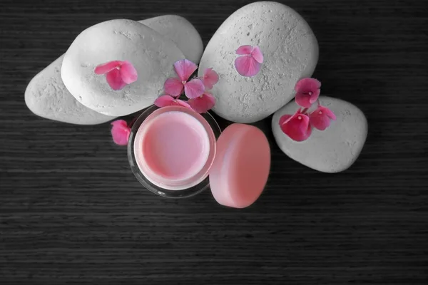 Крем для обличчя з рожевими пелюстками і галькою — стокове фото