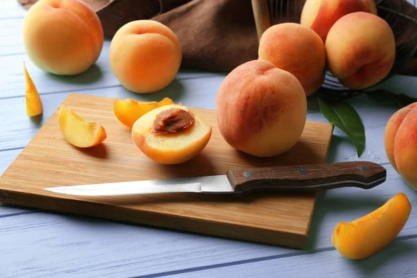 Ripe peaches on cutting board and turquoise wooden background — Stock Photo, Image