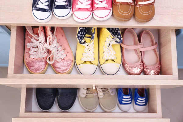 Different baby shoes in chest of drawers, top view — Stock Photo, Image