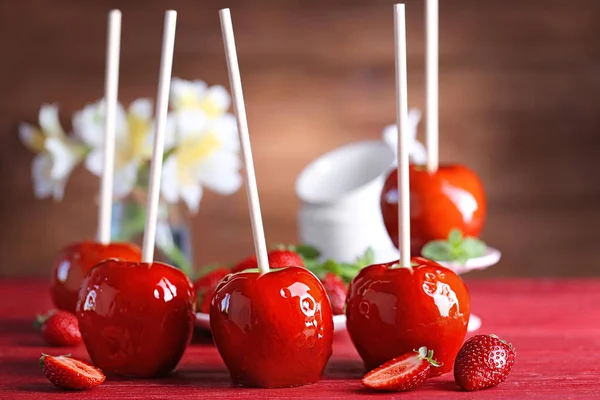 Pommes à bonbons à la fraise sur table en bois rouge — Photo