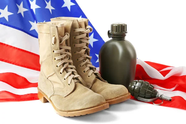 Coppia di stivali da combattimento, granata, borraccia e bandiera USA su sfondo bianco — Foto Stock