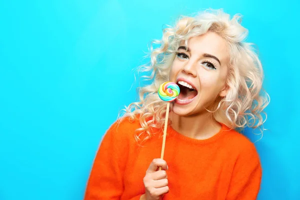 Portret van mooie mode meisje met lollipop op blauwe achtergrond — Stockfoto