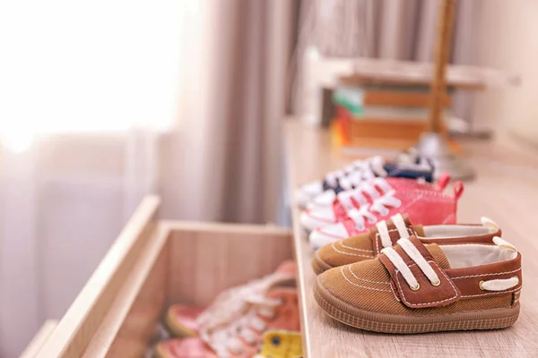 Different baby shoes on chest of drawers indoors — Stock Image Different baby shoes on chest of drawers indoors Royalty Free Stock Photos