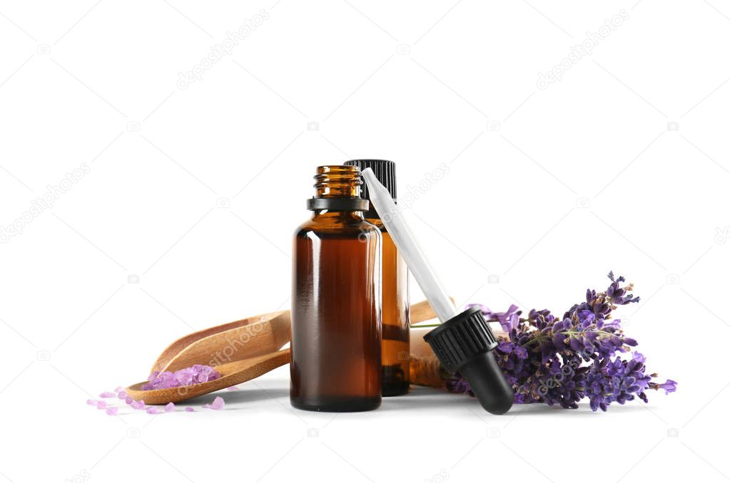 Bottles with aroma oil, sea salt and lavender flowers on white background