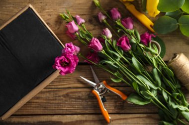 Ahşap arka plan kutusu ve çiçekçi ekipmanları ile güzel çiçekler