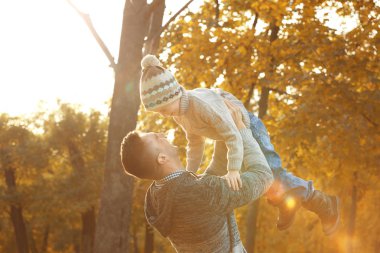 Baba ve oğul güzel sonbahar parkta oynarken