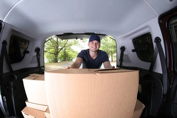 Joven macho entrega cajas de carga en el coche —  Fotos de Stock
