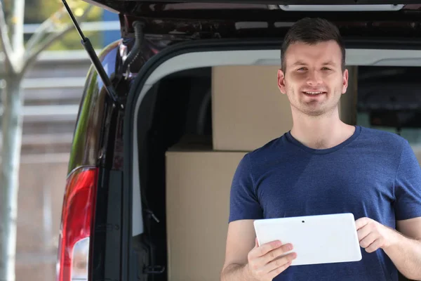 Male deliverer with tablet beside car — Stock Photo, Image