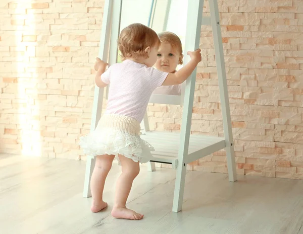 Putri kecil dengan gaun indah berpose di dekat cermin — Stok Foto