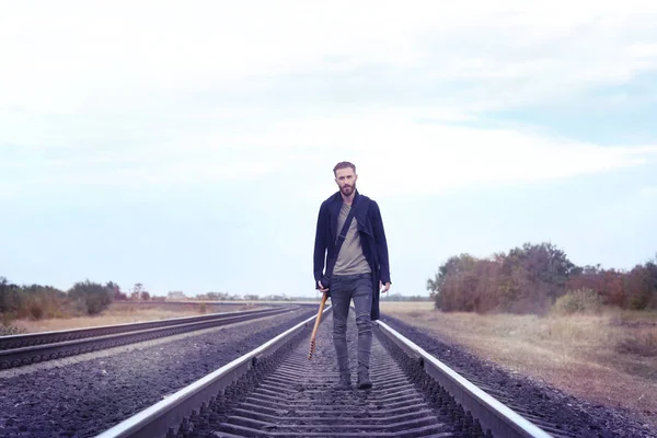 Schöner Mann mit Gitarre auf der Eisenbahn — Stockfoto