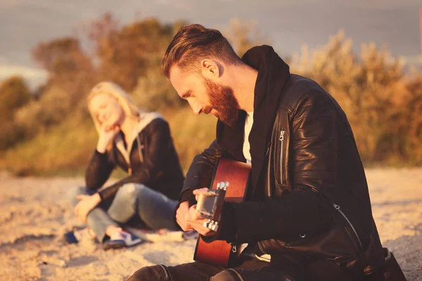 Uomo suonare la chitarra per la ragazza sulla spiaggia — Foto Stock