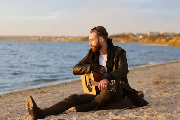 Schöner Mann mit Gitarre am Strand — Stockfoto