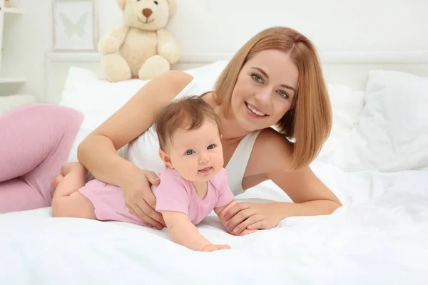 Young mother and baby lying on bed — Stock Photo, Image